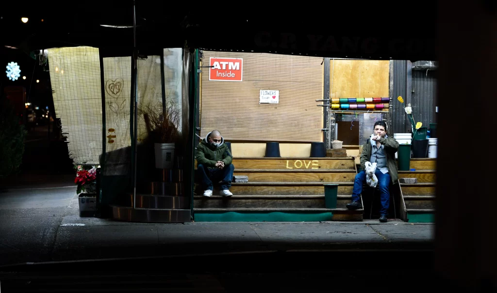 Deli flowers are brought inside when it is too cold, but the deli is still open. "Love" is written on the bare shelves.